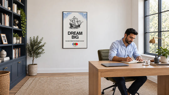 Dream Big canvas with sailing ship artwork on a home office wall beside a desk